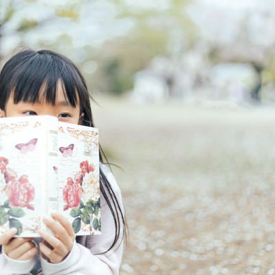 聖書を読みながら考え事をするクリスチャンの少女の写真