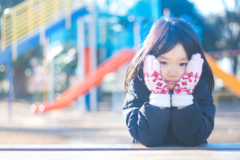 寒くてほっぺをおさえる女の子の写真