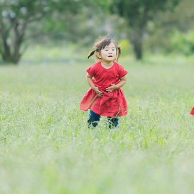 原っぱと双子の女児の写真