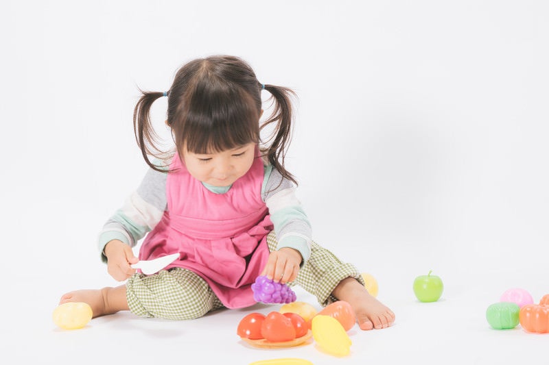 お皿に盛り付けするおままごと女児の写真