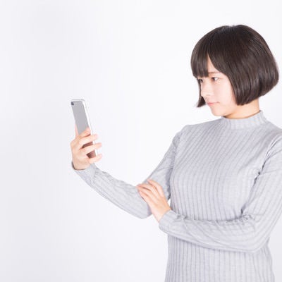 スマホを確認する女性の写真