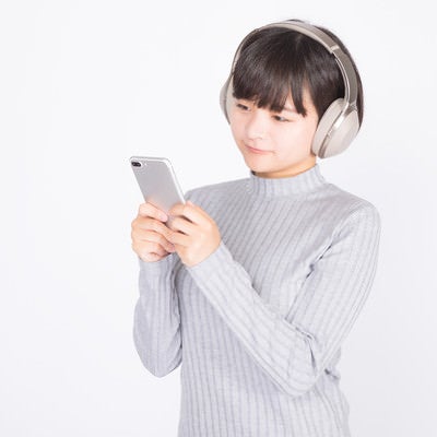 スマホで音楽を聴く女性の写真