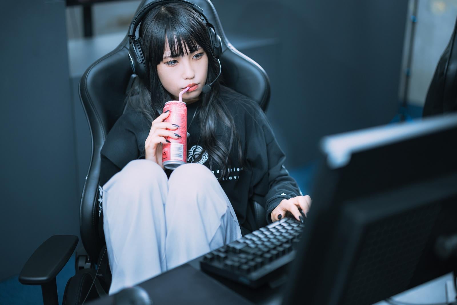 「エナドリを飲みながらゲーミングチェアで休憩中のゲーマー女子」の写真［モデル：るい］