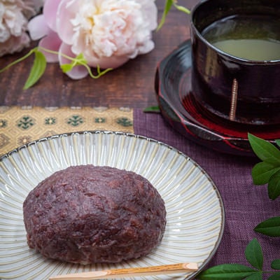 花で飾られたおはぎとお茶の写真