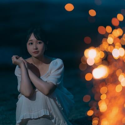 砂浜で花火を楽しむ女性の写真