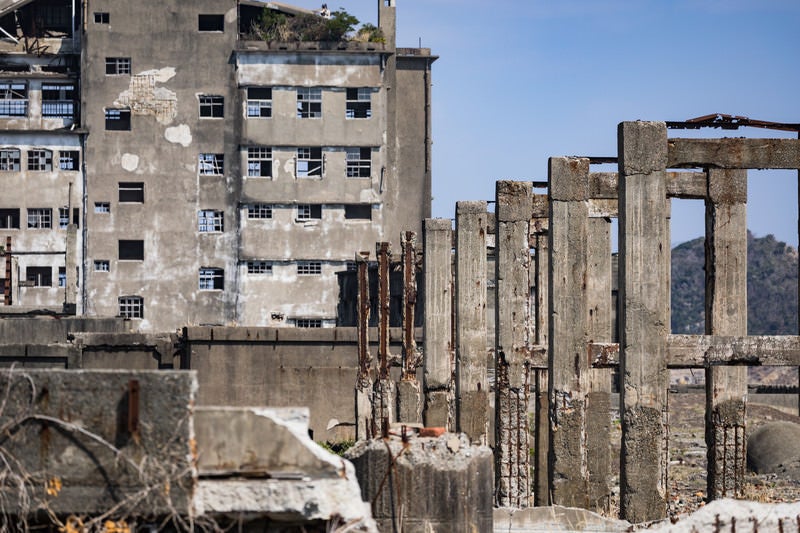 遠くに見える70号棟小中学校跡と貯炭場（軍艦島）の写真