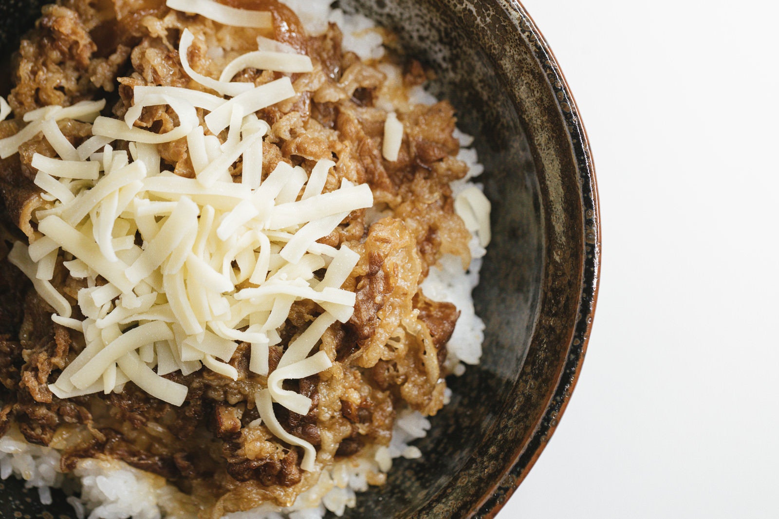 「とろけるチーズがトッピングされた牛丼」の写真