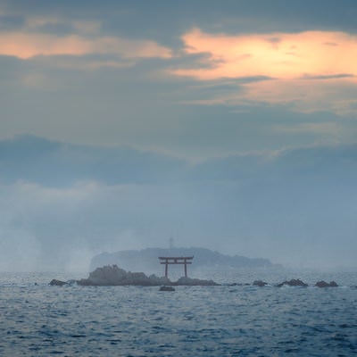 夕暮れの海に浮かぶ鳥居の写真