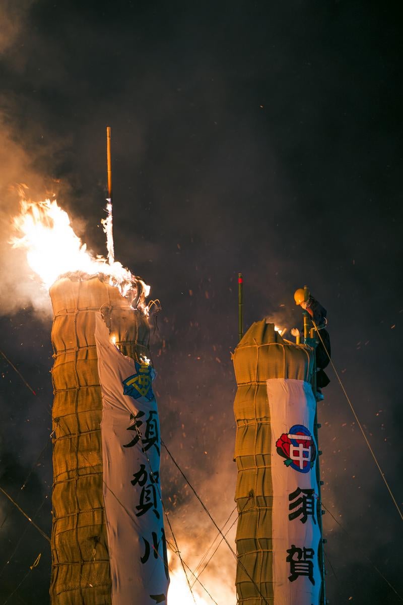 会場に飛び散る火花と大松明に点火する雄姿の写真