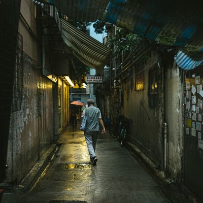 小雨が降る下町の路地裏と歩行者（香港）の写真