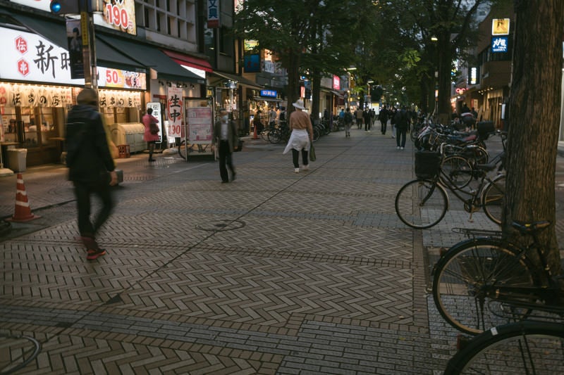 イセザキモールの歩道に停まる自転車と行き交う人々の写真