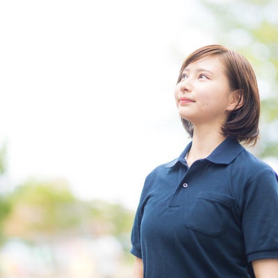 空を見上げるヘルパーの女性の写真