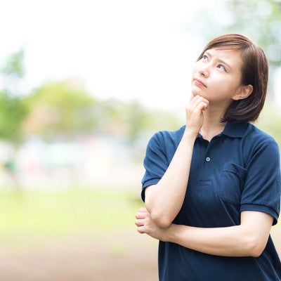 空を見上げて考え込むヘルパーの女性の写真