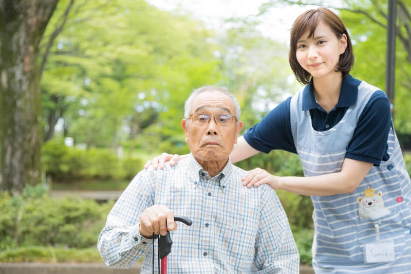 介護士さんと記念撮影するお爺さんの写真