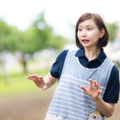 想定外の出来事が起きて慌てる女性介護士の写真