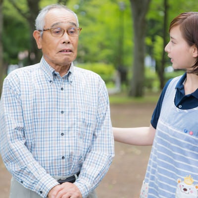 ひとりで外出してしまった老人と心配する介護士の写真