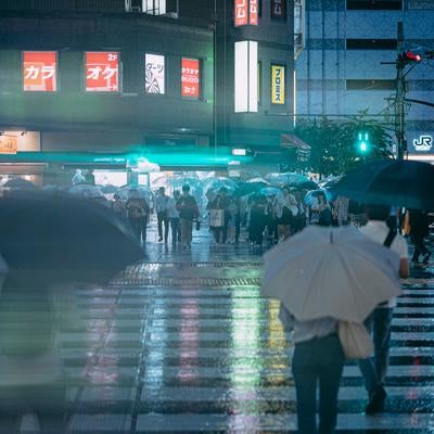 錦糸町駅の濡れた横断歩道と信号待ちする歩行者の写真