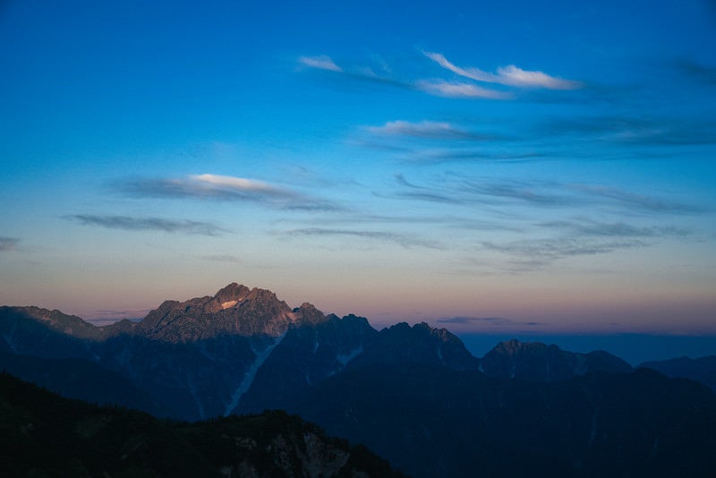 朝日を浴びる山々と朝焼けの写真