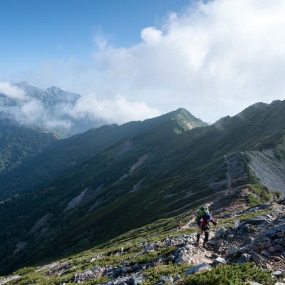 どこまでも続く稜線と登山者の写真