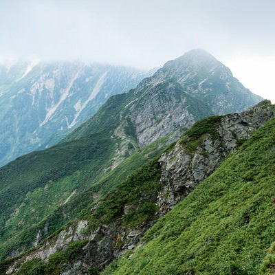 雲で隠れた岩尾根と切り立つ山々の写真