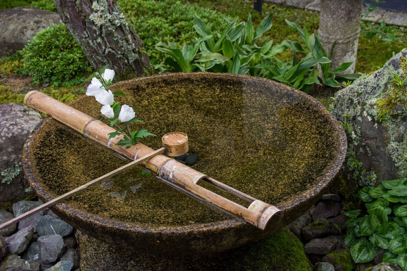 季節の花が飾られた水琴窟（すいきんくつ）の写真