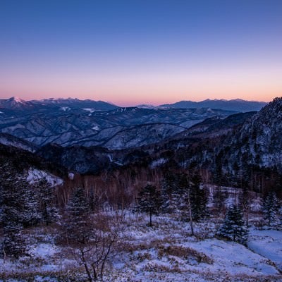 焼けた空と雪化粧の山々の写真