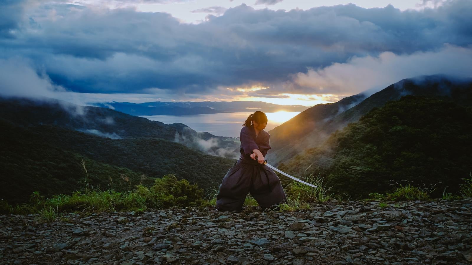 「夕焼けを背に刀を振り下ろすまーこ先生」の写真［モデル：まーこ先生］