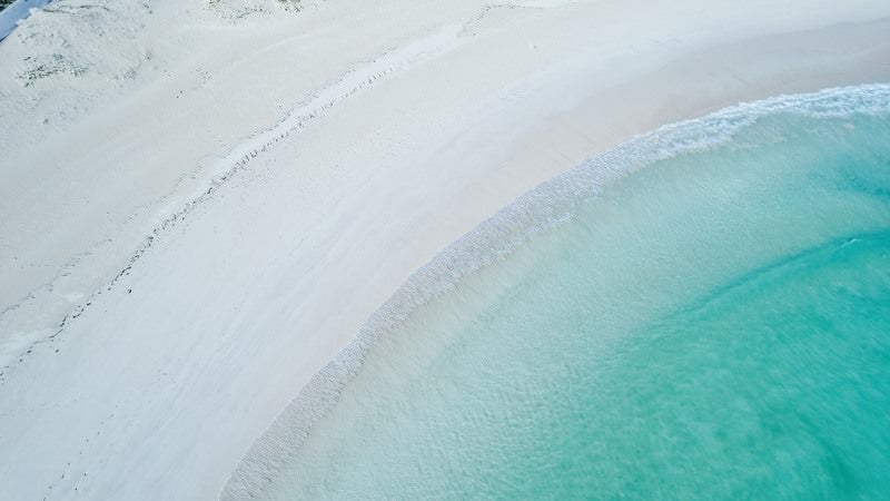 白い海岸に寄せる波の写真