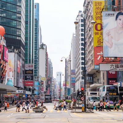 香港の都市部の景観と横断する人々の写真