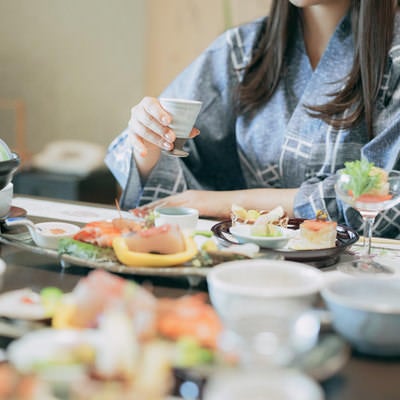 会席料理を食べる浴衣の女性の写真