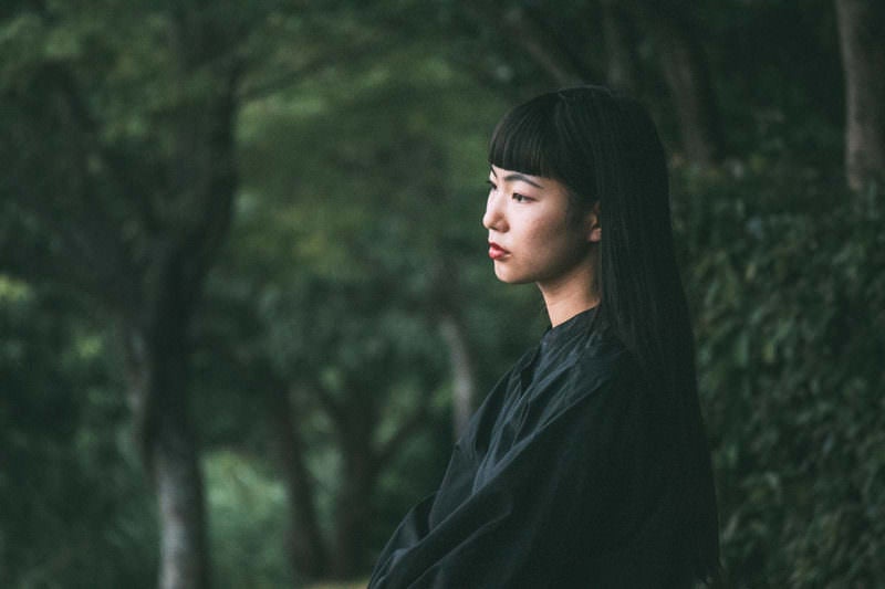 暗い森とロングヘアの女性の写真