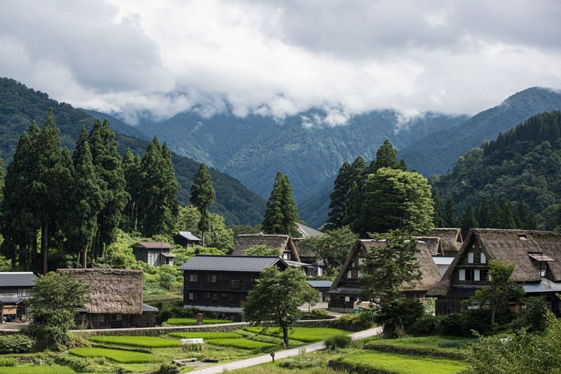 山に雲がかかる様子と相倉（あいのくら）合掌造り集落の写真