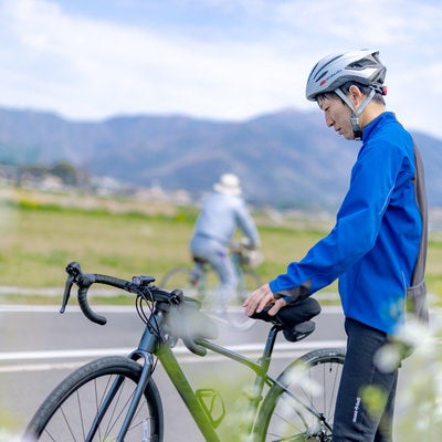 ロードバイクの状態をチェックする男性の写真