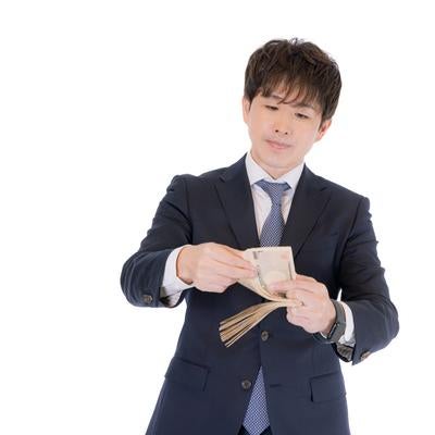 着手金を現金で受領し数えるM&Aコンサルタントの写真