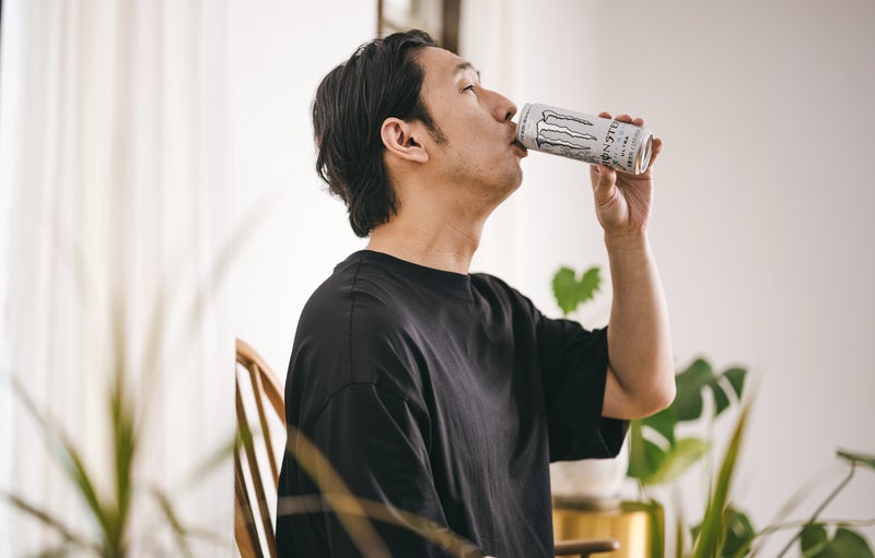 白いエナジードリンクを飲む男性の写真