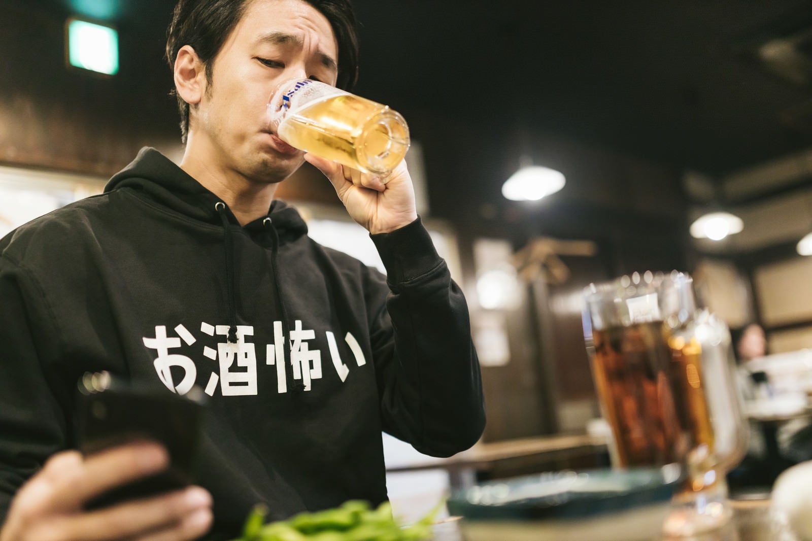 「炎上していくらお酒を飲んでも気がかりな男性」の写真［モデル：大川竜弥］