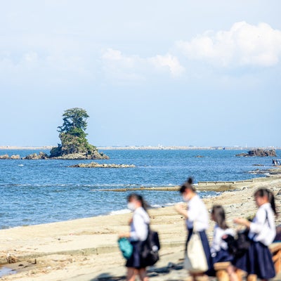 雨晴海岸の女岩 (めいわ)と女子学生の写真