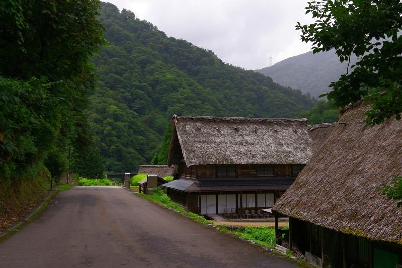 道路越しに見える集落（富山県南砺市）の写真