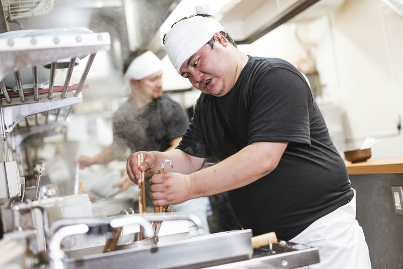 麺の硬さを見極めるラーメン職人の写真