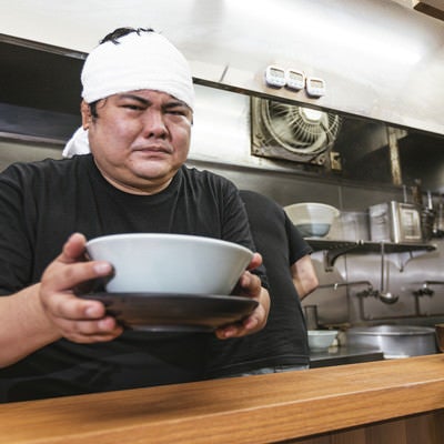 ラーメン評論家に怯えながらラーメンを提供する店主の写真