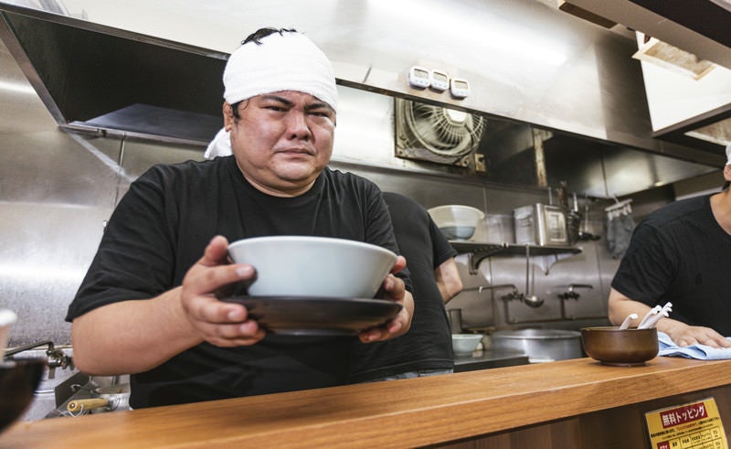 ラーメン評論家に怯えながらラーメンを提供する店主の写真