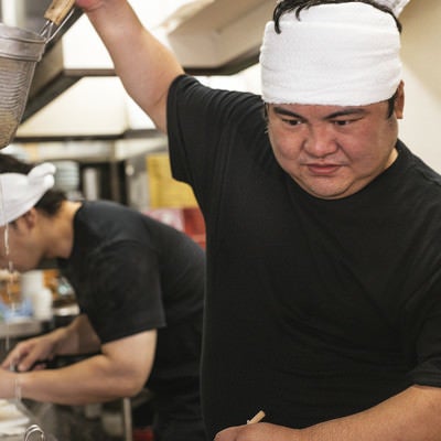 湯切り中に考え事をして止まる店主の写真