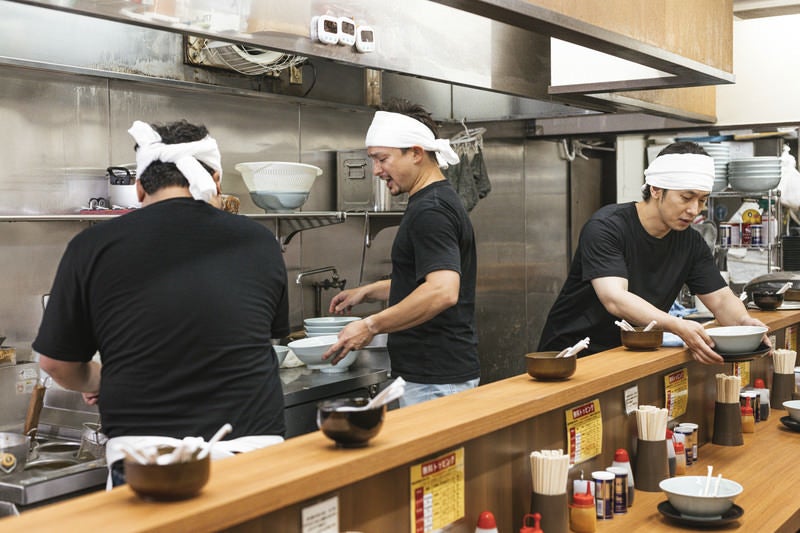 ラーメン屋で働く3人の店員の写真