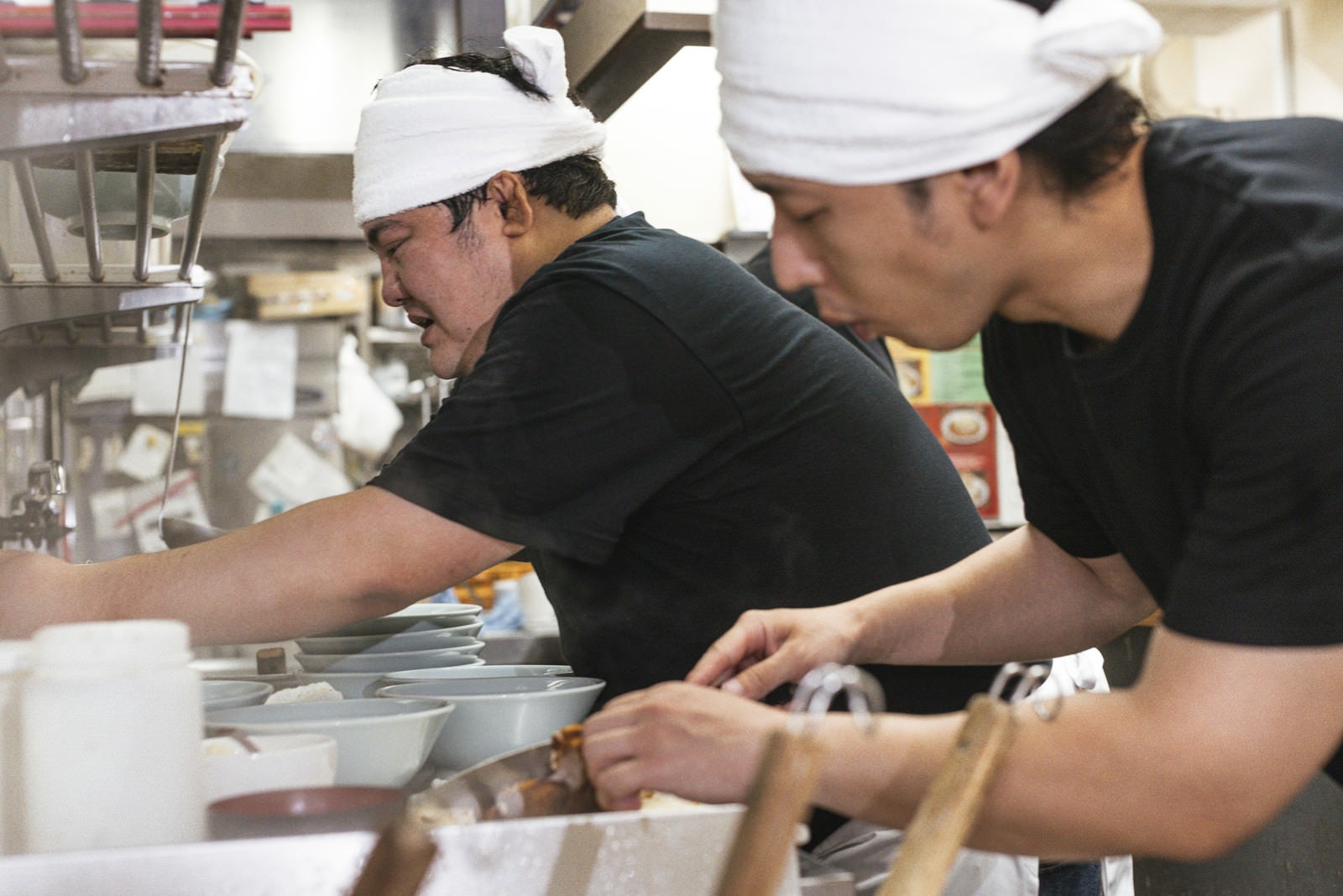 「忙しい雰囲気が伝わるラーメン屋の厨房」の写真［モデル：段田隼人 大川竜弥］