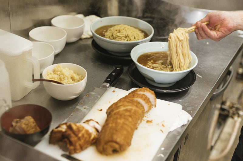 ラーメンどんぶりに麺をいれる様子の写真