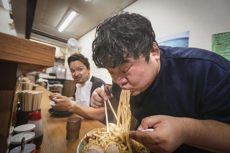 本能のままに麺をバキュームする客の写真