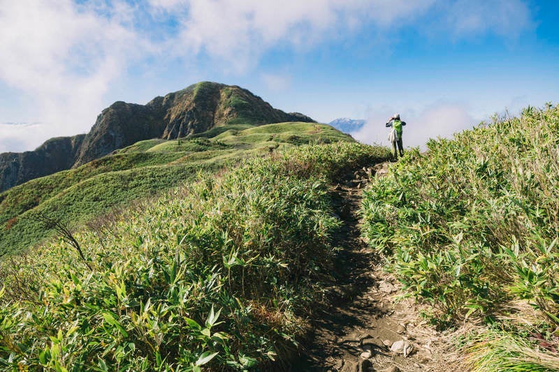 雨飾山山頂稜線と登山者の写真