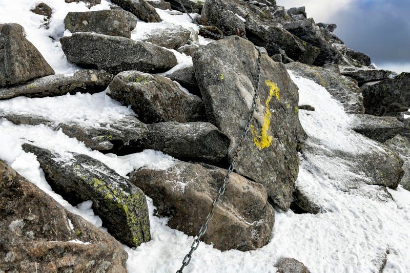 積雪と蓼科山山頂へ向かう矢印と鎖の写真