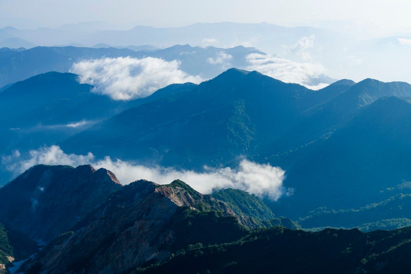 低い雲を纏った白山の山々の写真