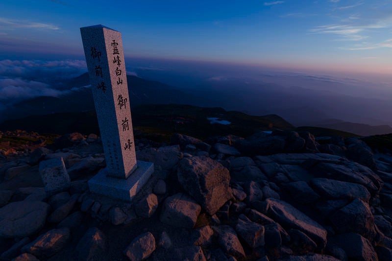 夕日で赤く焼けた御前峰山頂碑（白山）の写真